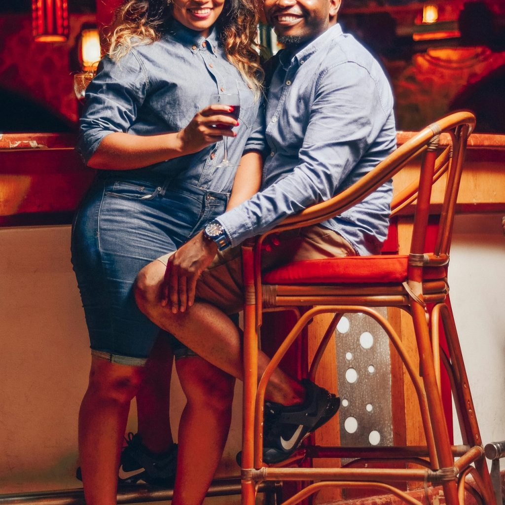 Soirée sensuelle dans un bar, couple complice et détendu dans une ambiance chaleureuse.