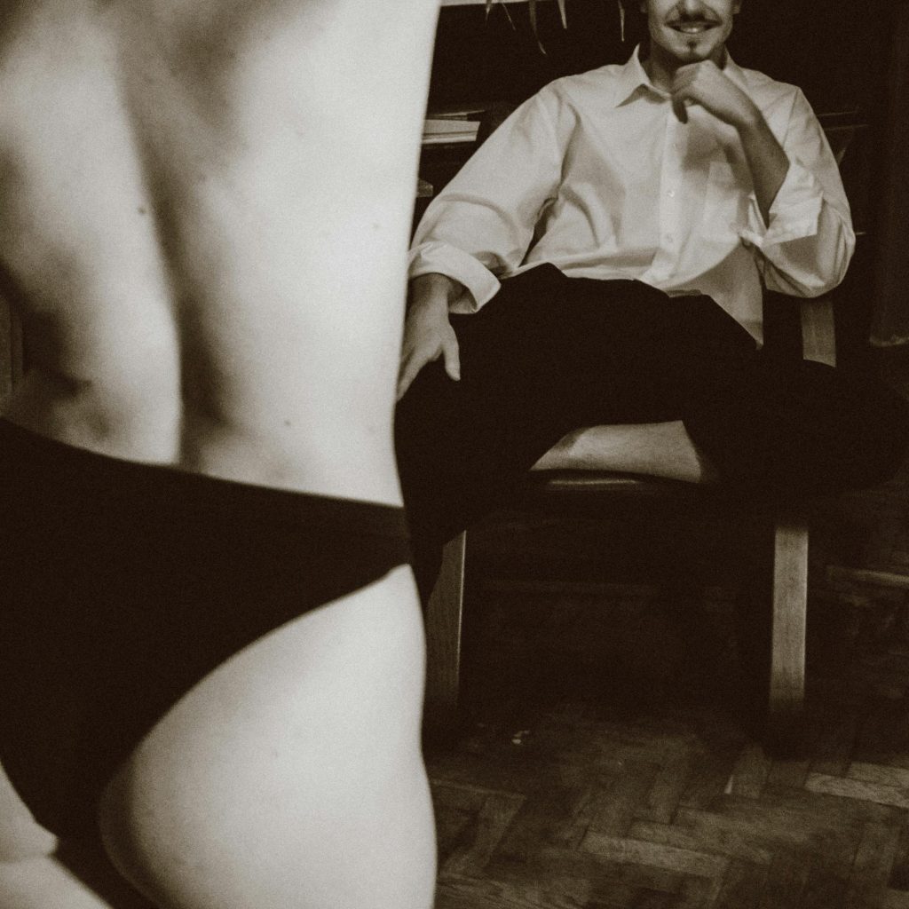 Jeu de séduction en couple, regard complice et tension érotique, scène de préliminaires sensuels en noir et blanc