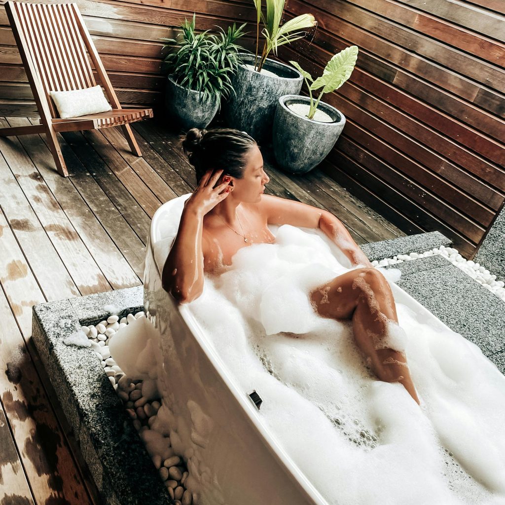 love room vs hôtel romantique Toulouse : Baignoire extérieure privative avec mousse dans un hébergement romantique.