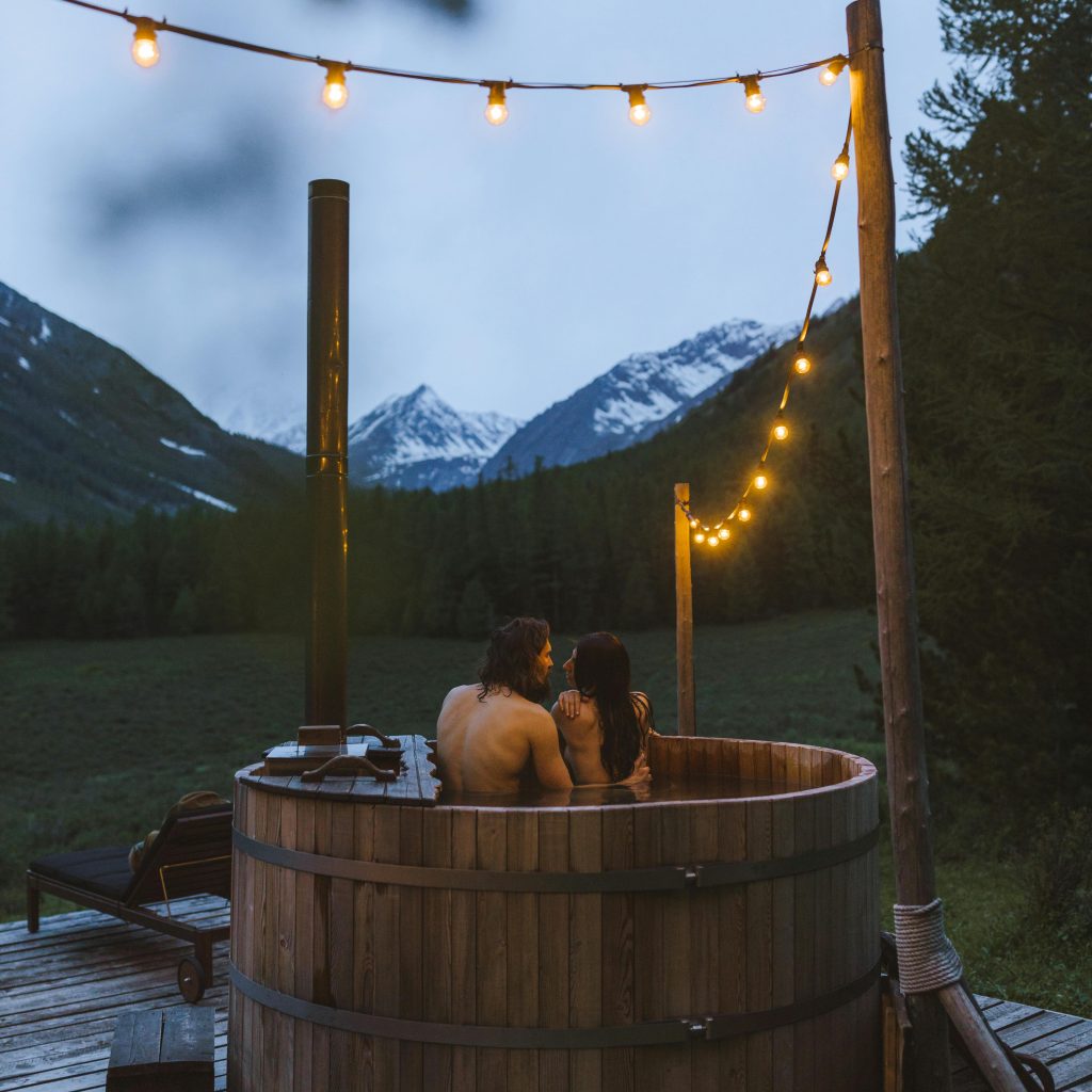 Couple profitant d’un jacuzzi extérieur en montagne, ambiance romantique façon love room à proximité de Toulouse.