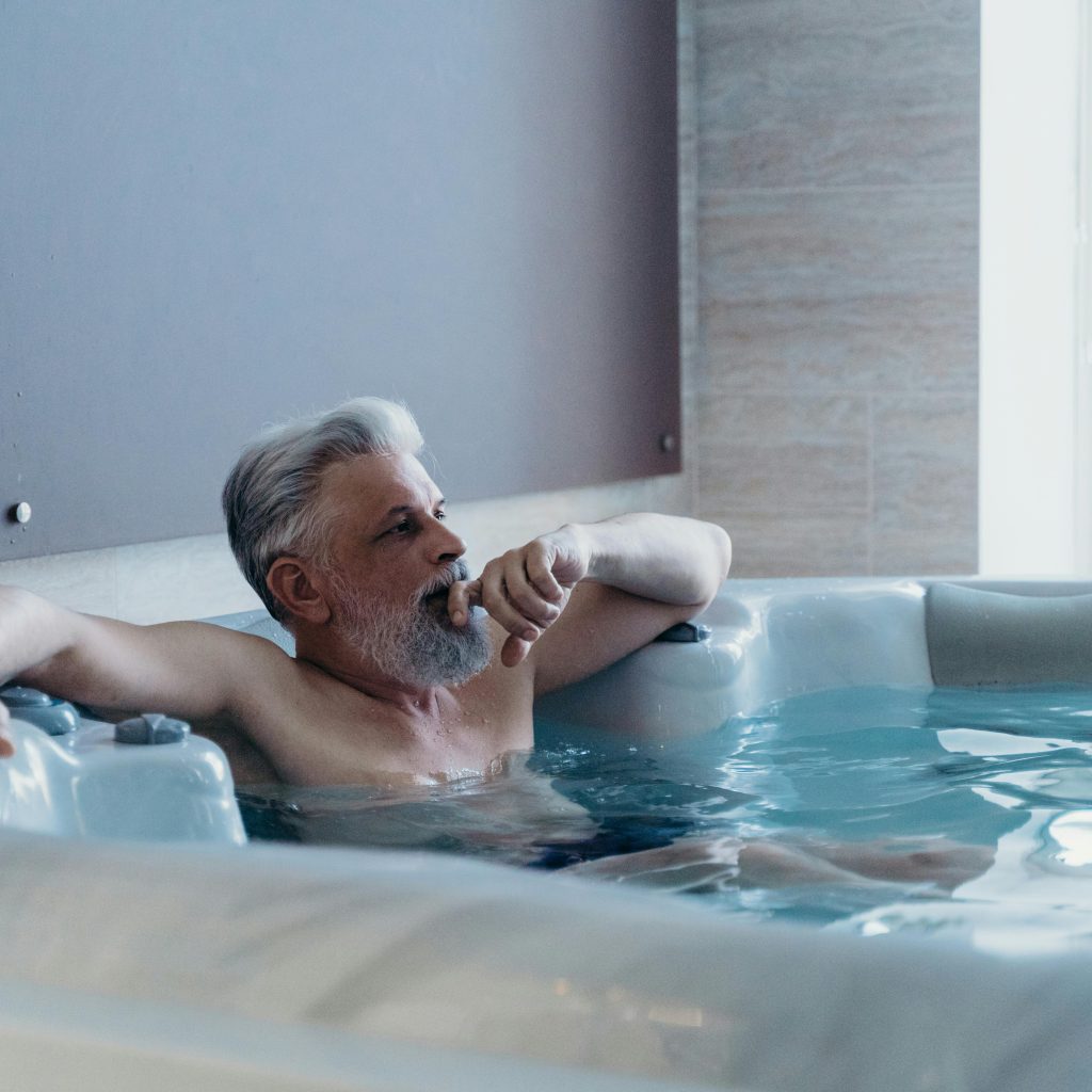 Homme profitant d’un moment de détente dans un jacuzzi d'une love room Toulouse jacuzzi