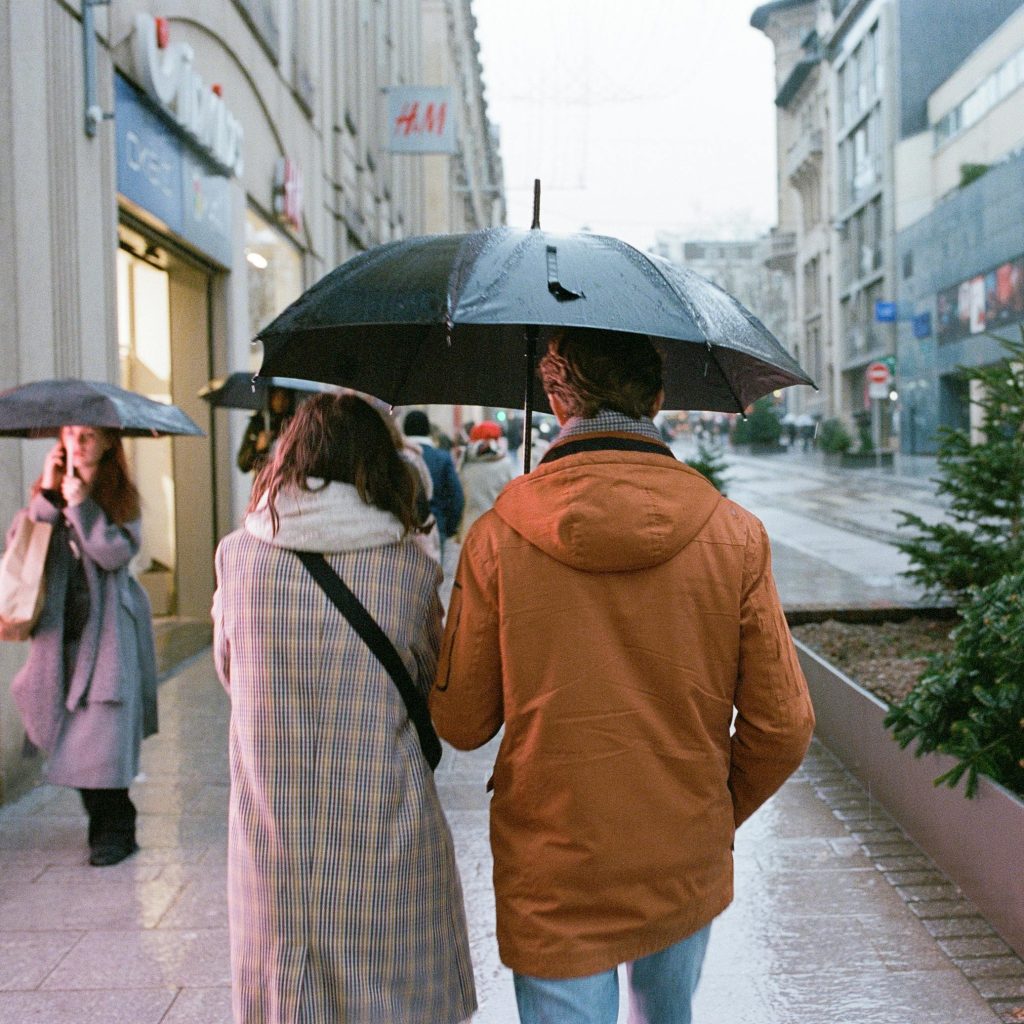 couple se baladant sous la pluie en ville pour un séjour romantique en love room dans le Grand Est