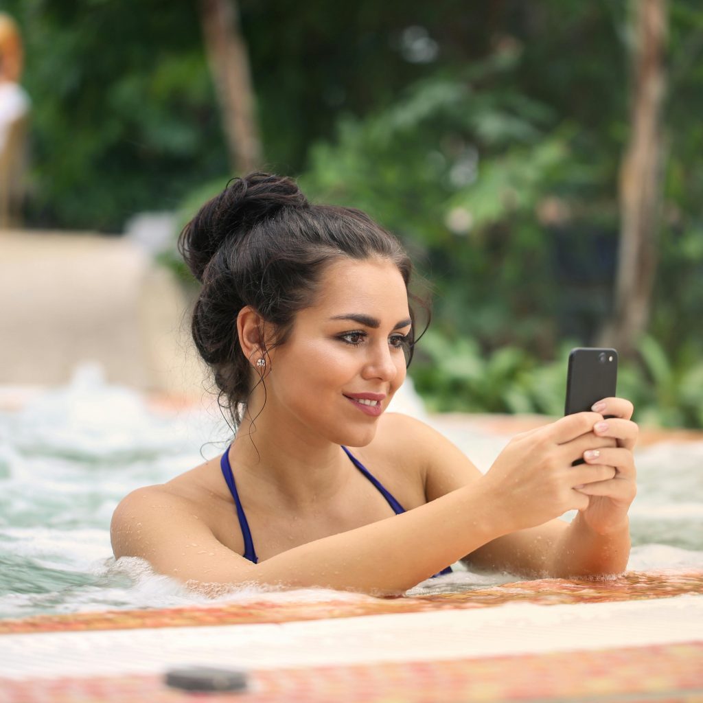 Jeune femme en maillot de bain posant dans une piscine luxueuse, créant une image de luxe et de romance pour une love room.