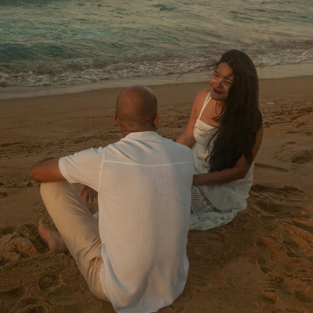 "Couple enlacé au bord de la mer en Bretagne, regardant le soleil couchant. Une image parfaite pour illustrer un séjour romantique et intime.