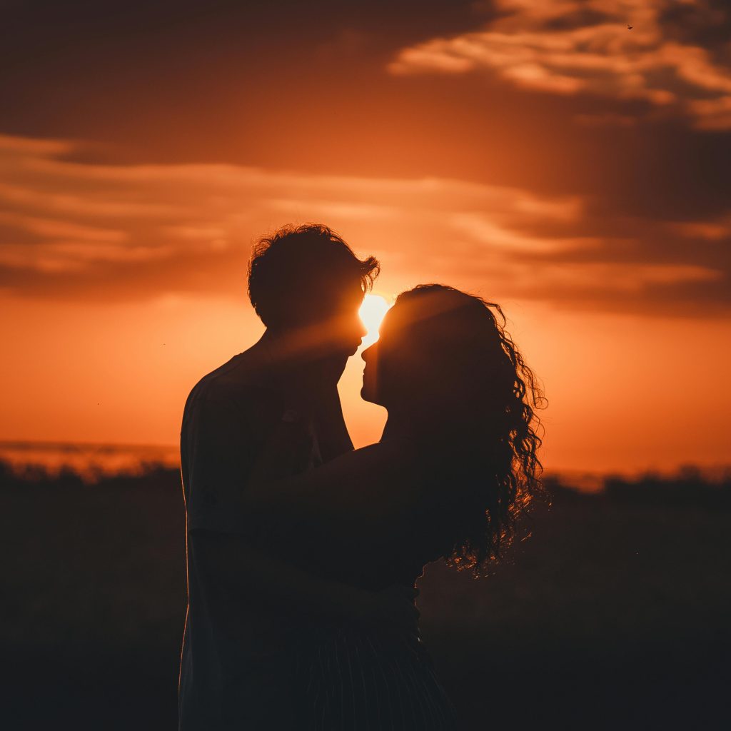 Couple profitant du coucher de soleil depuis le balcon du love room 