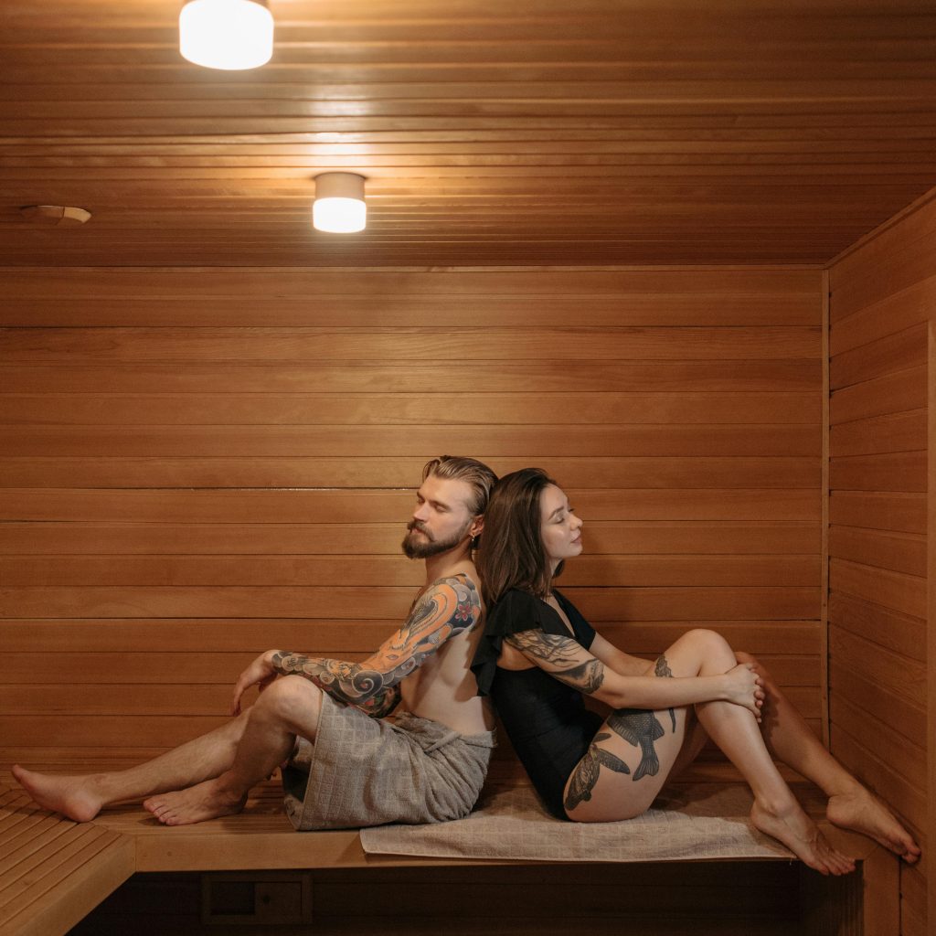 Couple relaxant dans un sauna haut de gamme d’une love room en Bretagne pour un séjour de luxe à deux